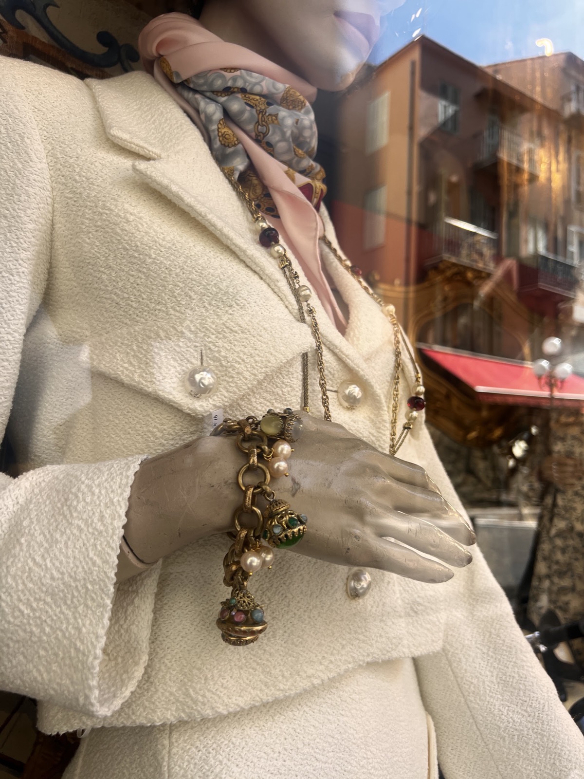 Tailleur en tweed ivoire, carré de soie et bijoux sur mannequin de vitrine
